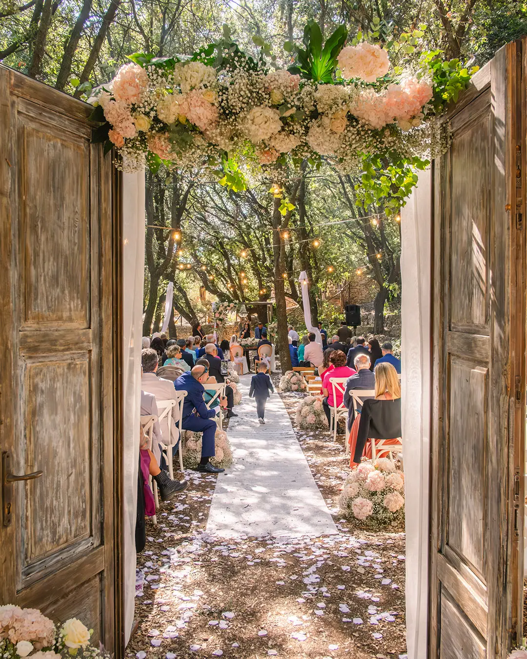 Arco floreale all'ingresso di una cerimonia all'aperto
