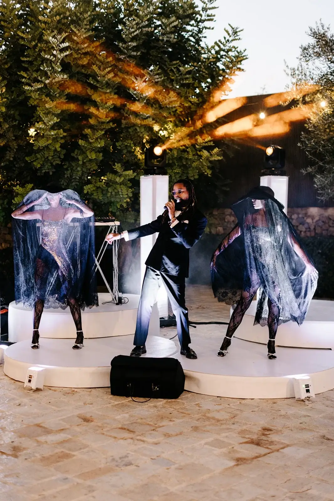 Performer con ali luminose su un palco all'aperto